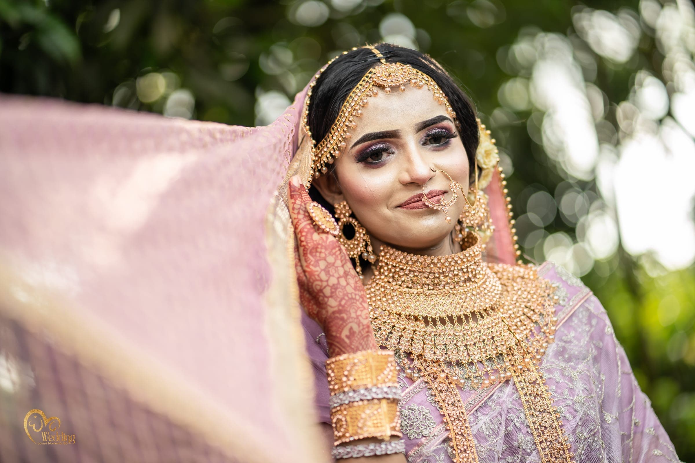 Bride lifting a lilac veil in soft outdoor light